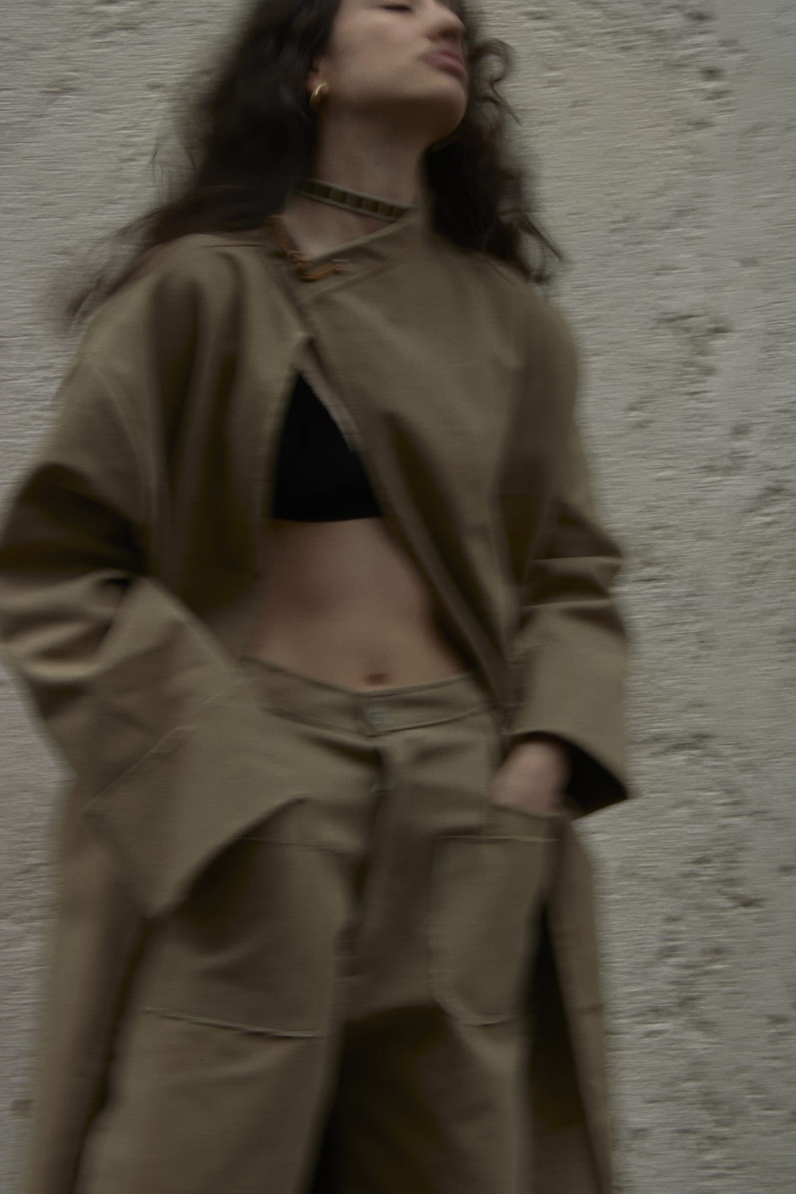 Model in the FRAME coat and trousers, close up against a pale wall