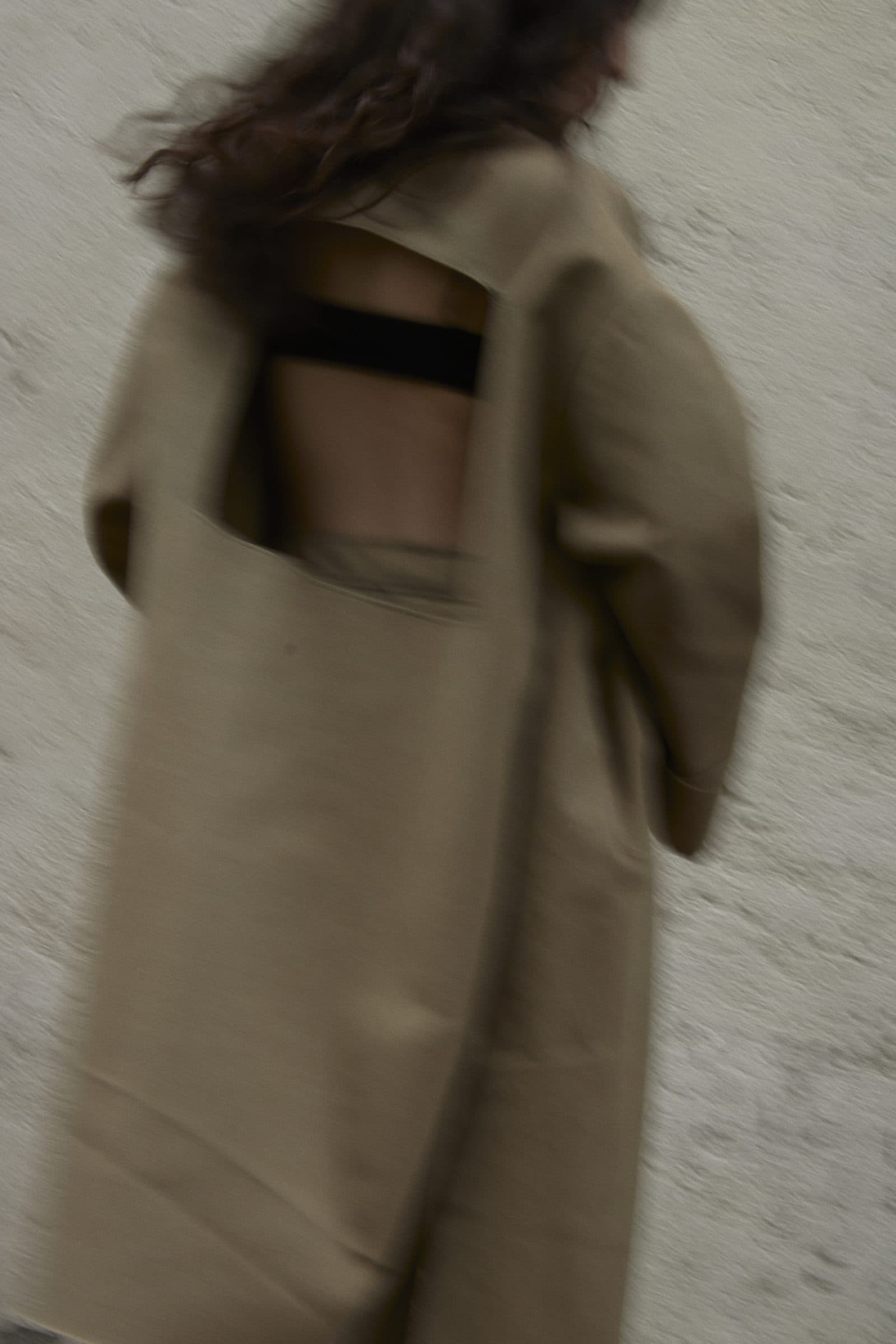 The open back of the FRAME coat, in motion