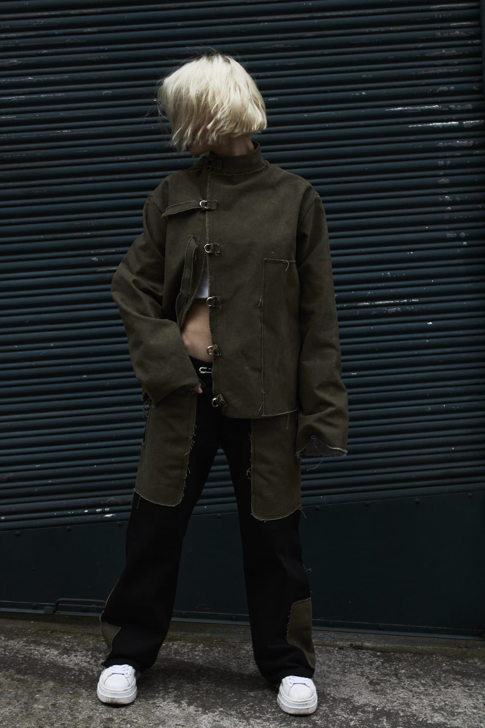 AKIN jacket, full look, against a blue rolling shutter